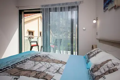 a bedroom with a bed and a large window at Fortress View apartment II in Kotor