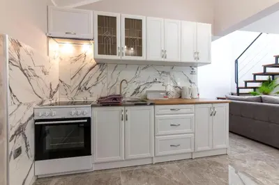 a kitchen with white cabinets and a stove at Fortress View apartment II in Kotor