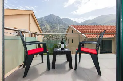 two chairs and a table with a bottle of wine on a balcony at Fortress View apartment II in Kotor