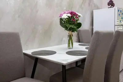 a vase of flowers on a table with chairs at Fortress View apartment II in Kotor