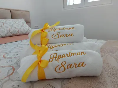 a stack of towels on a bed with a yellow ribbon at Apartment Sara with seaview in Budva