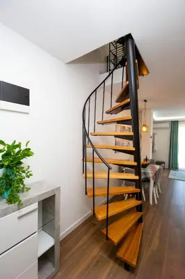 a black and wooden spiral staircase in a living room at Apartment Sara with seaview in Budva