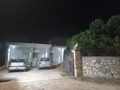 two cars parked in front of a house at night at Studio Apartman Susanj Bar in Bar