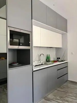 a kitchen with white cabinets and a microwave at AURA TOWER Apartments by Gaby in Rafailovici