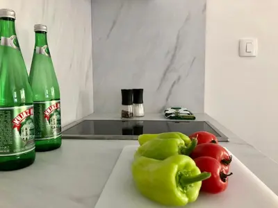 two bottles of soda and some green peppers on a counter at AURA TOWER Apartments by Gaby in Rafailovici