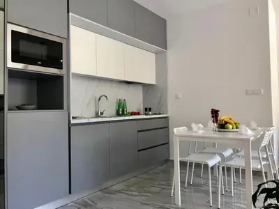 a white kitchen with a white table and chairs at AURA TOWER Apartments by Gaby in Rafailovici