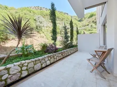 a patio with a stone wall and a table and a whiteboard at AURA TOWER Apartments by Gaby in Rafailovici