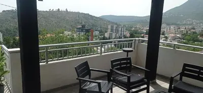 two chairs on a balcony with a view of a city at VuJo in Sutomore