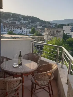 a table and chairs with a bottle of wine on a balcony at Mari in Ulcinj