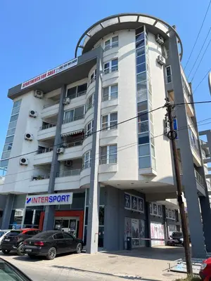 a large building with cars parked in front of it at Mari in Ulcinj
