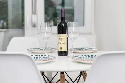 a bottle of wine sitting on a table with glasses at Studio apartman Scardona in Kotor
