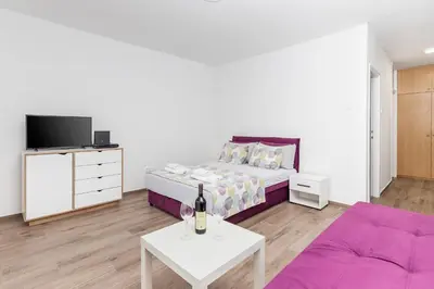 a living room with a bed and a couch at Studio apartman Scardona in Kotor