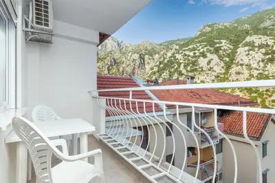 a balcony with white chairs and a view of mountains at Studio apartman Scardona in Kotor
