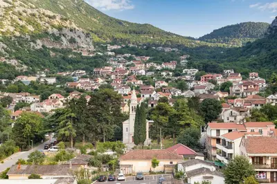 a town in the mountains with houses and cars at Studio apartman Scardona in Kotor