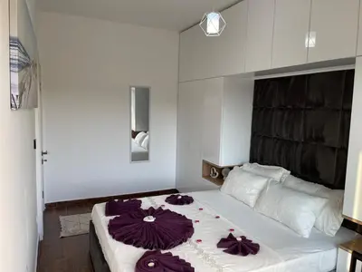a bedroom with a large bed with purple flowers on it at Capitol Apartments in Ulcinj