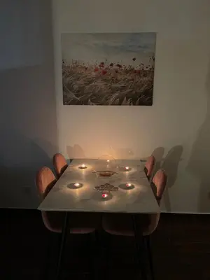 a dining room table with candles and a painting at Capitol Apartments in Ulcinj