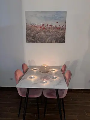 a dining room table with candles and a painting on the wall at Capitol Apartments in Ulcinj
