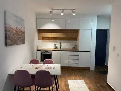 a kitchen with a table and chairs in a room at Capitol Apartments in Ulcinj