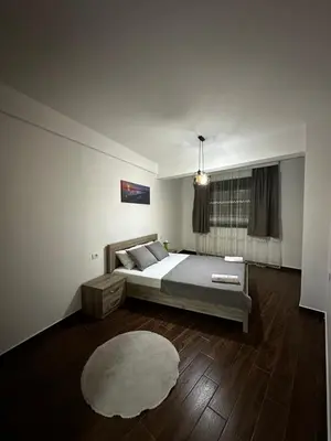 a bedroom with a bed and a rug at Capitol Apartments in Ulcinj