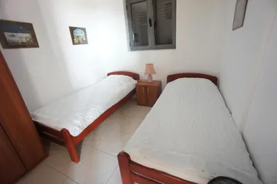 a room with two beds and a lamp on a table at Apartments Bečići Sunset in Budva
