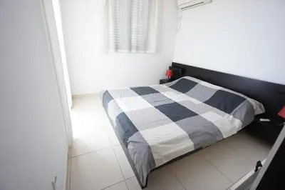 a bedroom with a bed with a checkered blanket at Apartments Bečići Sunset in Budva