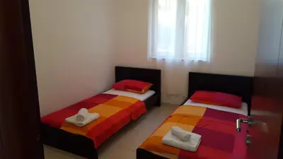 two beds in a small room with colorful sheets at Apartments Bečići Sunset in Budva