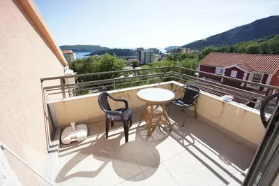 a balcony with a table and chairs on a balcony at Apartments Bečići Sunset in Budva