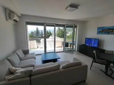 a living room with a couch and a table at Apartman Sara in Pržno