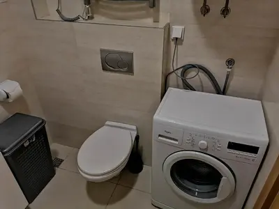 a bathroom with a washing machine and a toilet at Apartman Sara in Pržno