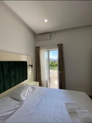 a bedroom with a large white bed and a sliding glass door at Heaven Home in Ulcinj
