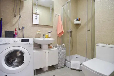 a bathroom with a washing machine and a sink at Full of light, relaxing, calming apartment in BD in Budva