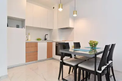 a kitchen with a dining room table and chairs at Full of light, relaxing, calming apartment in BD in Budva