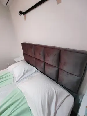 a bed with a brown padded headboard in a room at Horizont Dobre Vode in Dobra Voda