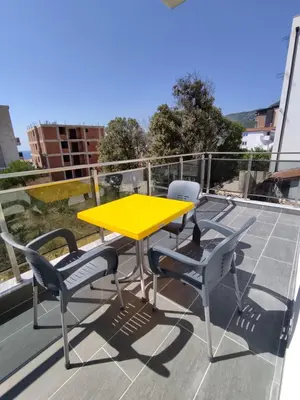 a yellow table and two chairs on a roof at Horizont Dobre Vode in Dobra Voda