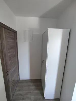 a room with a white refrigerator and a door at Horizont Dobre Vode in Dobra Voda