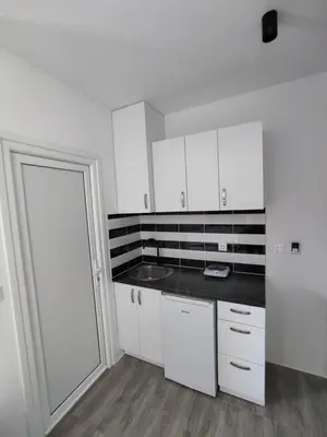 a kitchen with white cabinets and a sink at Horizont Dobre Vode in Dobra Voda