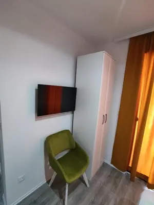 a green chair in a room with a cabinet at Horizont Dobre Vode in Dobra Voda