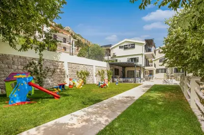 a yard with playground equipment in front of a building at Dekaderon Lux Apartments in Kotor