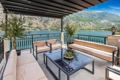 a patio with furniture and a view of the water at Dekaderon Lux Apartments in Kotor