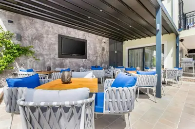 a patio with tables and chairs and a tv at Dekaderon Lux Apartments in Kotor