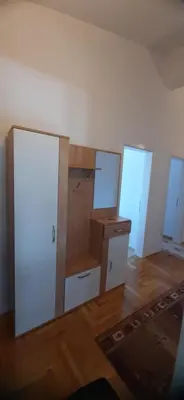 an empty room with three doors and a wooden floor at Apartmani Paradise in Sutomore