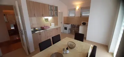 a kitchen with a table and chairs and a kitchen with a sink at Apartmani Paradise in Sutomore