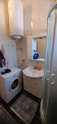 a small bathroom with a washing machine and a sink at Apartmani Paradise in Sutomore