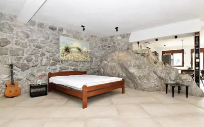 a bedroom with a bed and a rock wall at The Rock Star's Villa with Private Pool and Beach in Danilovgrad