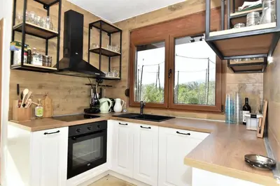 a kitchen with white cabinets and a sink and windows at The Rock Star's Villa with Private Pool and Beach in Danilovgrad