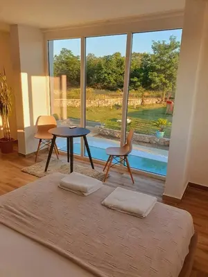 a bedroom with a bed and a table and chairs at The Rock Star's Villa with Private Pool and Beach in Danilovgrad