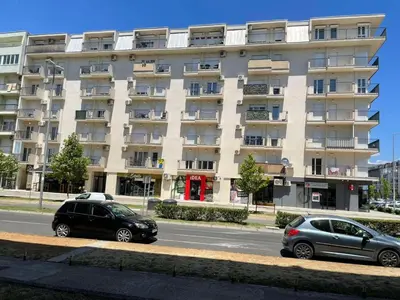 two cars parked in front of a large building at KENZA jednosobni stanovi in Podgorica