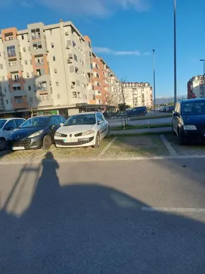 a shadow of a person standing in a parking lot at KENZA jednosobni stanovi in Podgorica