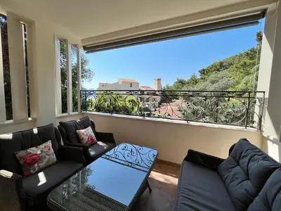 a living room with a couch and a large window at Vista Petrovac in Petrovac na Moru