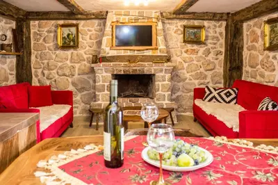 a living room with a table with a bottle of wine at Old stone house with swimming pool Etno House Perazic in Bar